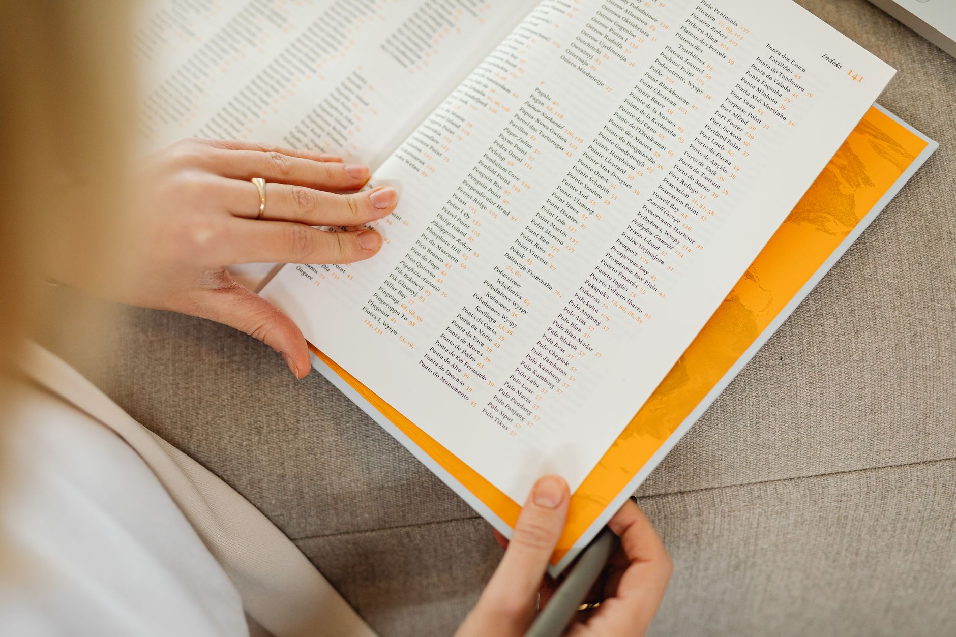 A person holding two printed pages side by side and comparing the text.