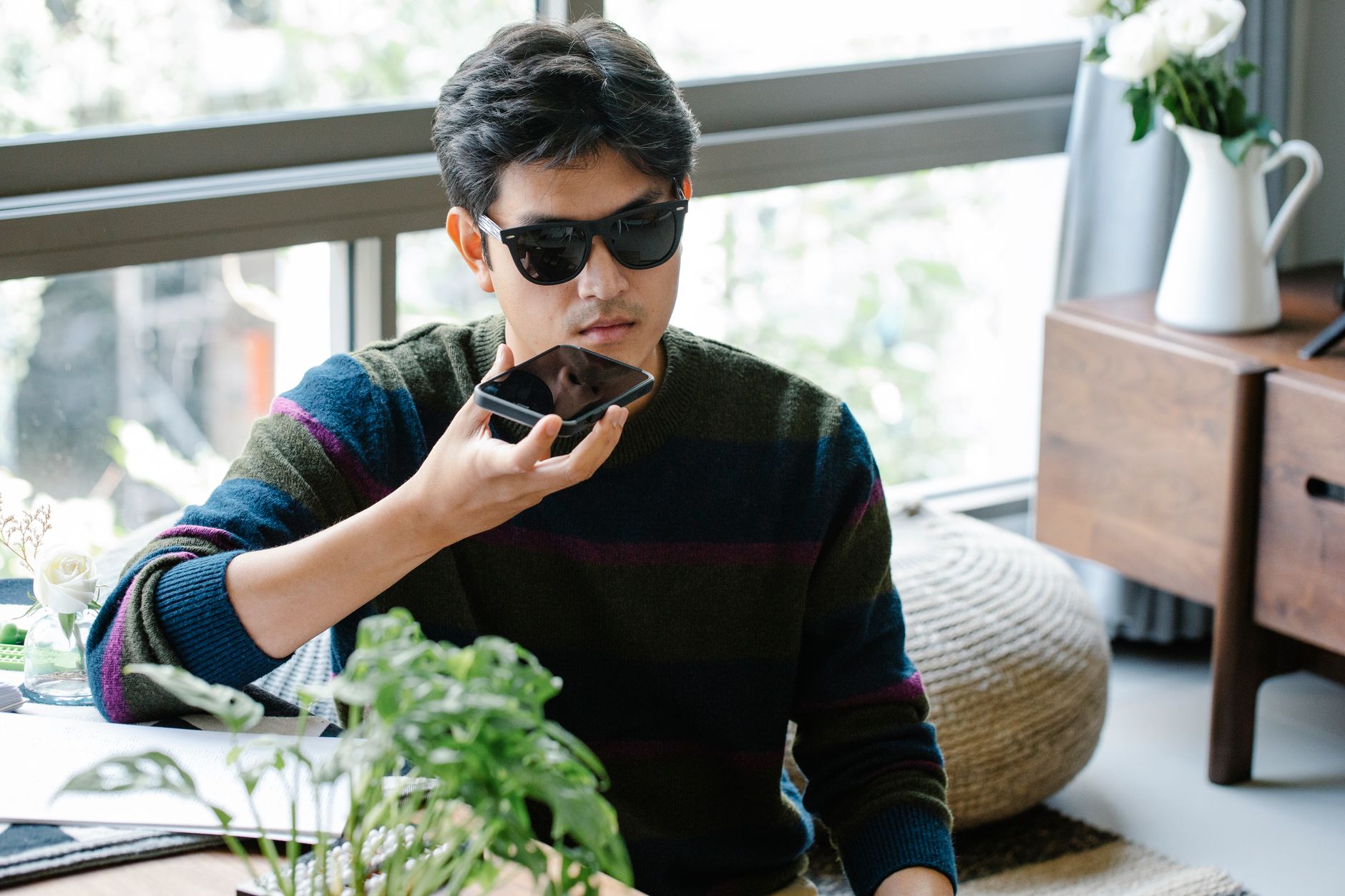 Person talking to Gemini voice assistant on a smartphone at a desk