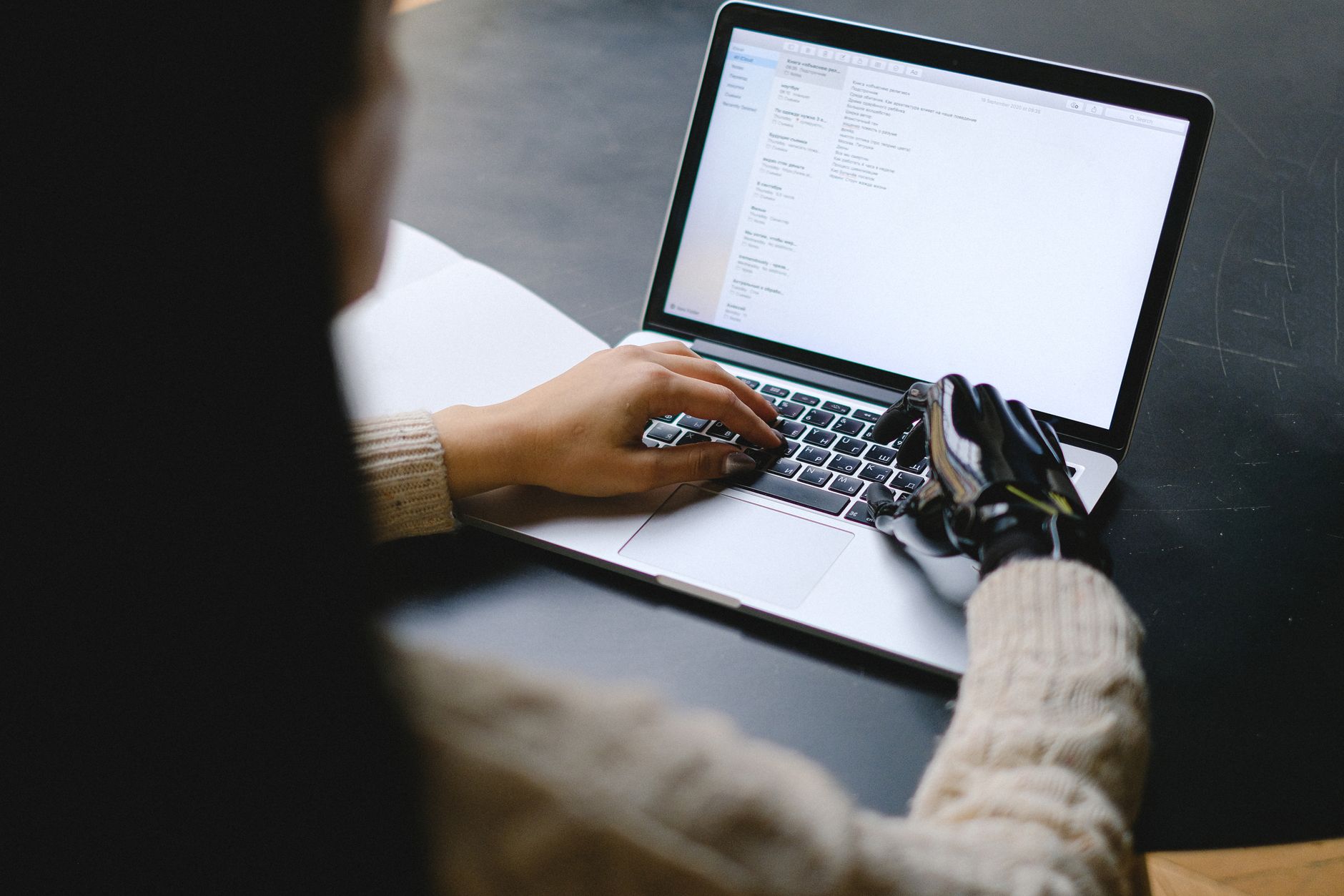 A person types an essay on a laptop while an AI chat window shows suggestions.
