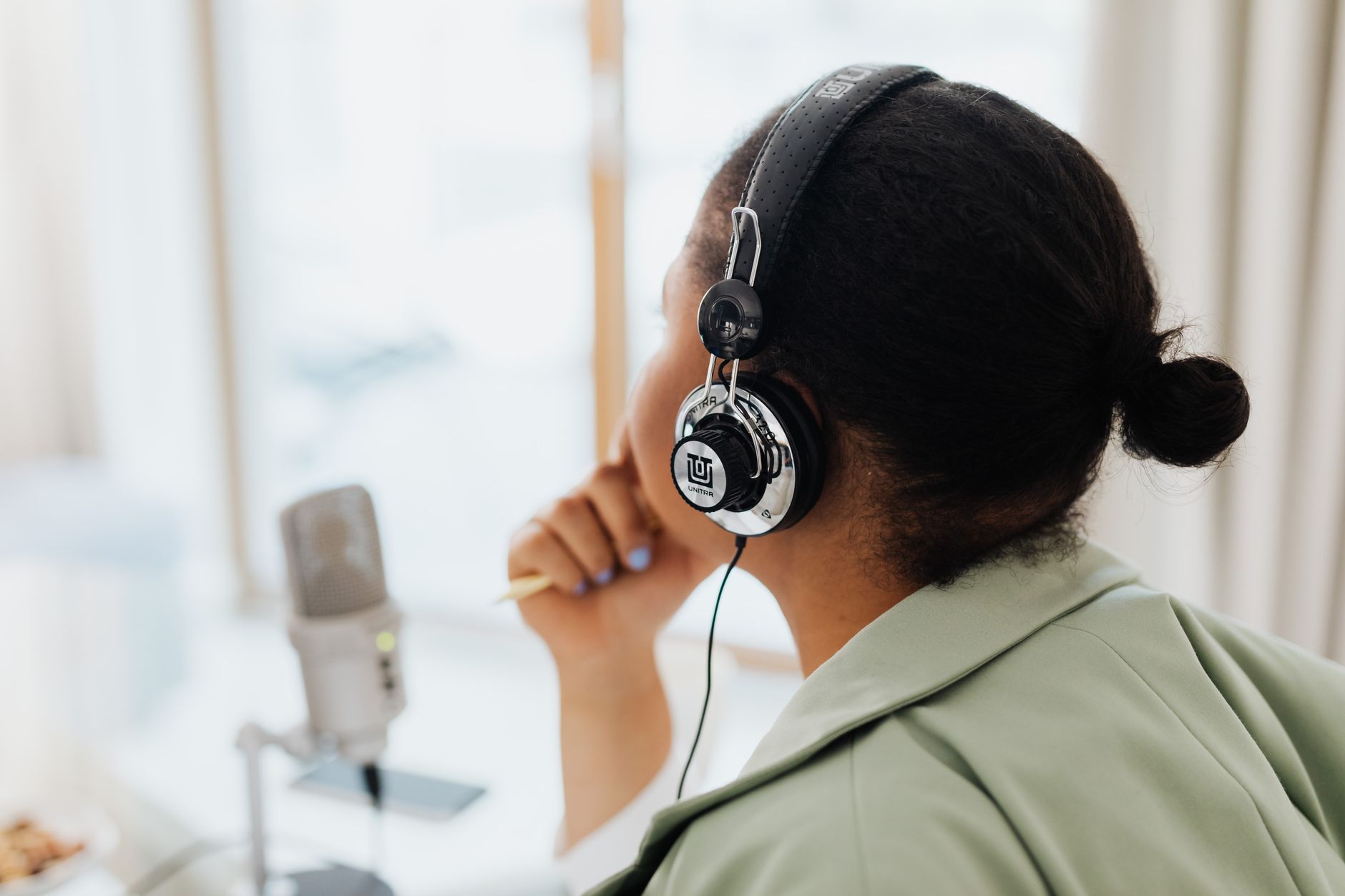 Person wearing headphones listening to a podcast on a phone